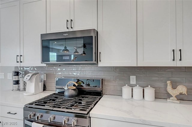 8349 Pollenzo Ave, Las Vegas, NV 89178 - kitchen featuring stainless steel appliances, white cabinetry, and backsplash