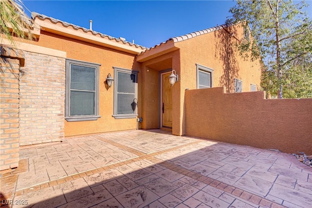 437 Via Stretto Ave, Henderson, NV 89011 - doorway to property with a patio area, stucco siding, a tiled roof, and fence