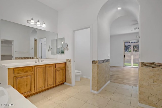 437 Via Stretto Ave, Henderson, NV 89011 - full bathroom with tile patterned flooring, toilet, vanity, tile walls, and wainscoting