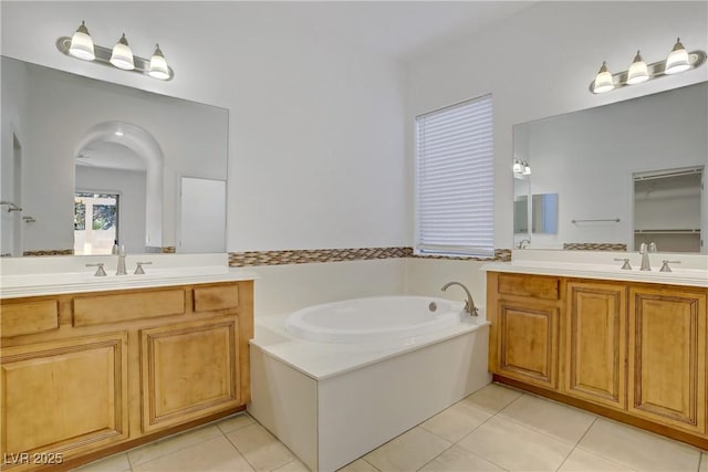 437 Via Stretto Ave, Henderson, NV 89011 - bathroom featuring a bath, two vanities, tile patterned flooring, and a sink