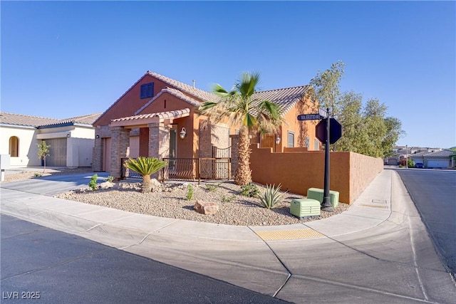 437 Via Stretto Ave, Henderson, NV 89011 - view of front of home with a tiled roof, a fenced front yard, stucco siding, an attached garage, and driveway