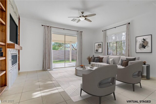 437 Via Stretto Ave, Henderson, NV 89011 - living room featuring a fireplace, a ceiling fan, visible vents, and a healthy amount of sunlight