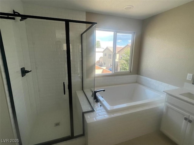 bathroom featuring a bath, a stall shower, and vanity