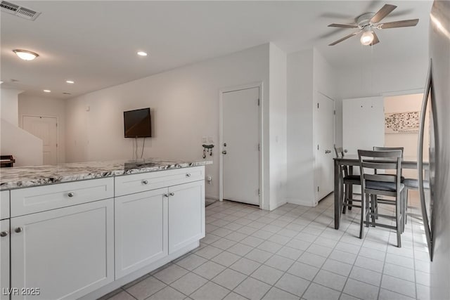 5256 Sherwood Forest Ln, Las Vegas, NV 89122 - kitchen with stainless steel fridge, recessed lighting, white cabinetry, a ceiling fan, and visible vents