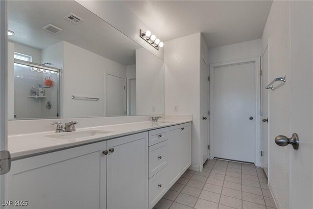 5256 Sherwood Forest Ln, Las Vegas, NV 89122 - bathroom featuring a sink, visible vents, double vanity, and a shower with door