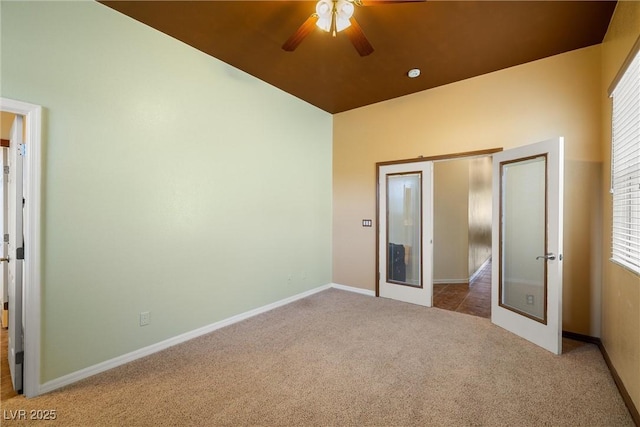 unfurnished bedroom featuring french doors, multiple windows, baseboards, and carpet floors