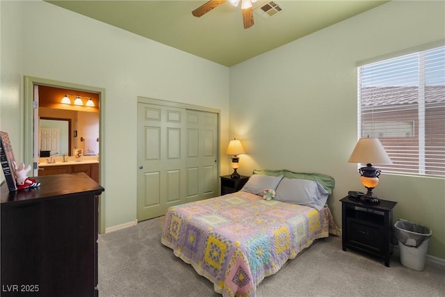 carpeted bedroom with visible vents, baseboards, a closet, and ensuite bathroom