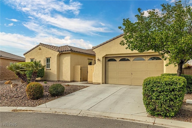 mediterranean / spanish-style home featuring a tiled roof, a garage, stucco siding, a gate, and driveway
