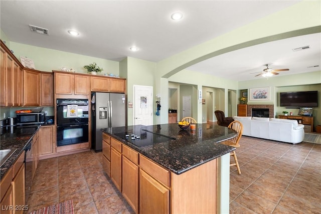 kitchen featuring a center island, ceiling fan, black appliances, and visible vents