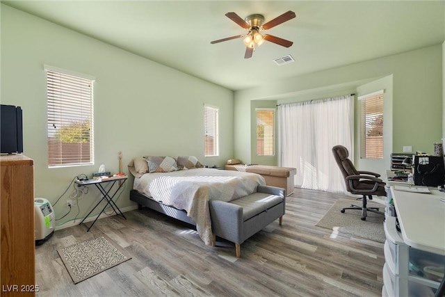 bedroom featuring visible vents, a ceiling fan, and wood finished floors