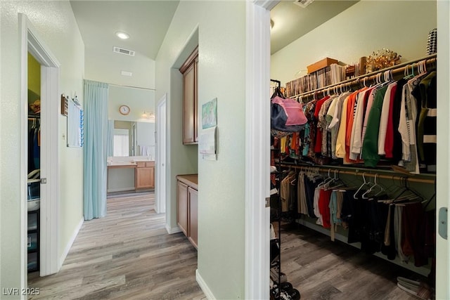 walk in closet featuring wood finished floors and visible vents