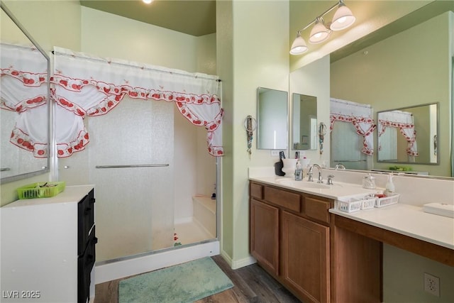 bathroom with a stall shower, wood finished floors, and vanity
