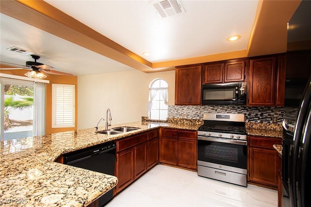 kitchen featuring visible vents, a sink, black appliances, and light stone counters