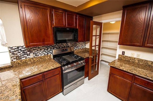 kitchen with stainless steel gas stove, black microwave, dark stone countertops, reddish brown cabinets, and decorative backsplash