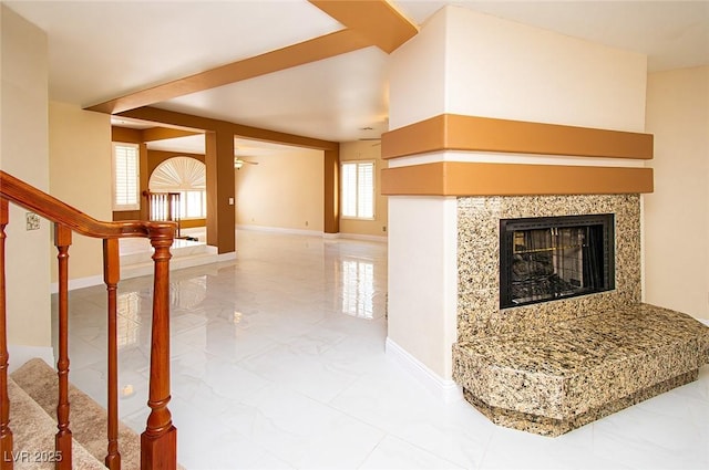 unfurnished living room with baseboards, marble finish floor, a fireplace, and stairs