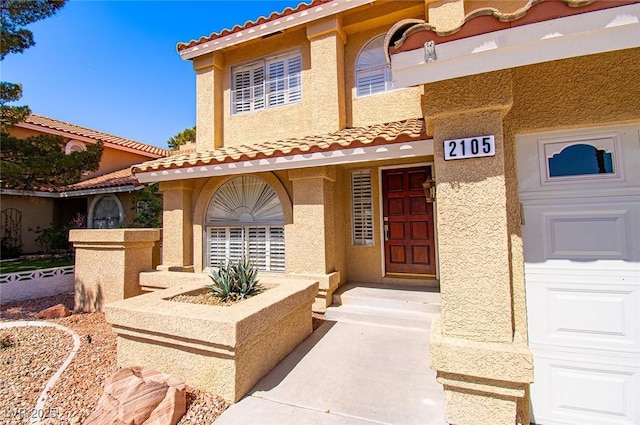 entrance to property featuring stucco siding and a tiled roof