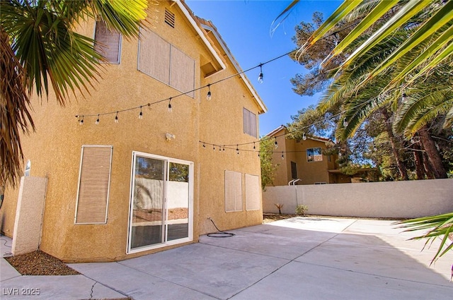 back of house featuring a patio area, stucco siding, and fence
