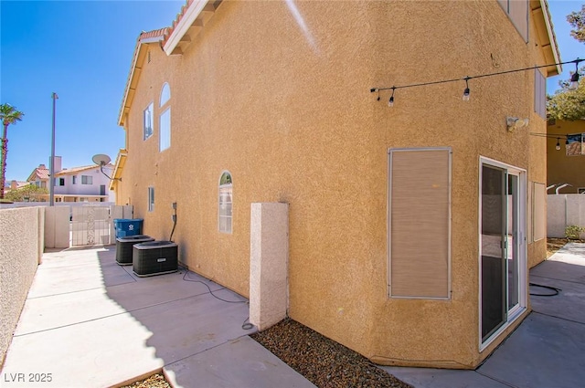 view of property exterior featuring fence, a patio, and stucco siding