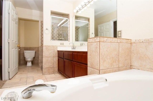 full bath featuring vanity, tile patterned flooring, toilet, a washtub, and tile walls
