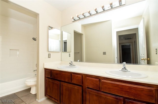 bathroom featuring a sink, tile patterned floors, toilet, and double vanity
