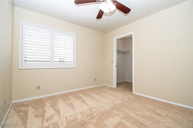 unfurnished bedroom featuring carpet, a closet, a ceiling fan, a spacious closet, and baseboards