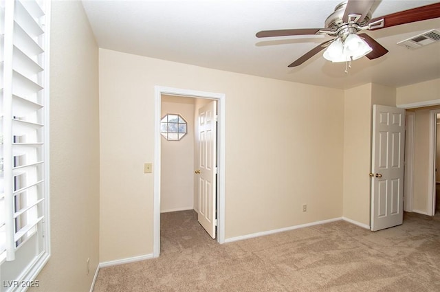 unfurnished bedroom featuring light carpet, visible vents, and baseboards
