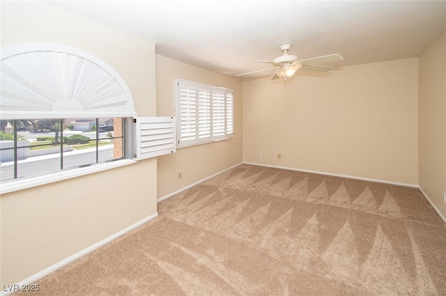 carpeted empty room with baseboards and ceiling fan