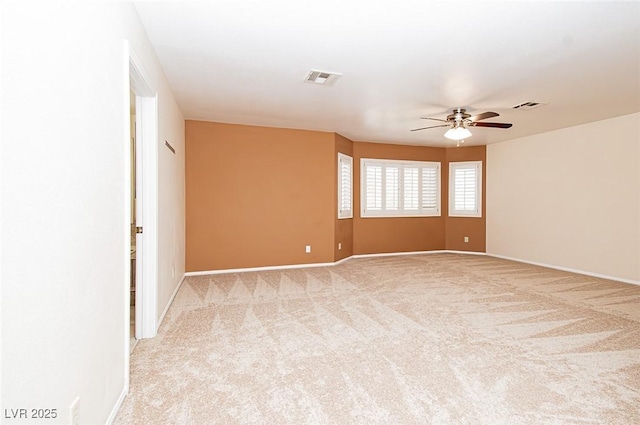 unfurnished room with baseboards, visible vents, light colored carpet, and a ceiling fan
