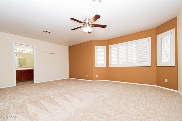 empty room with visible vents, ceiling fan, light colored carpet, and baseboards