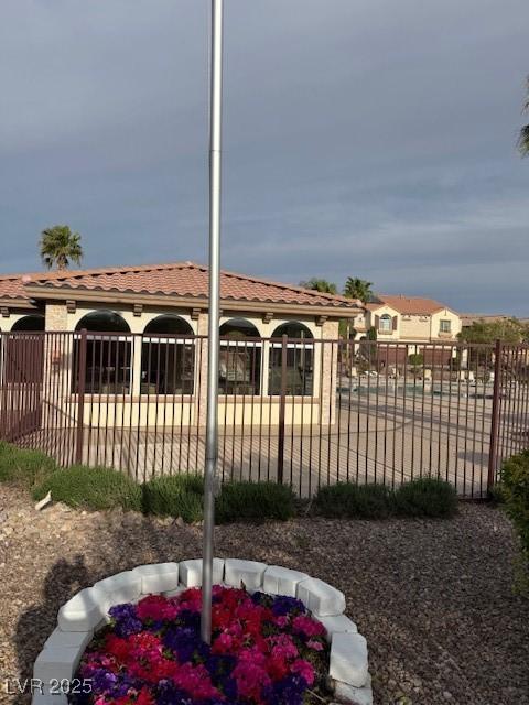 exterior space featuring stucco siding, fence, and a tile roof