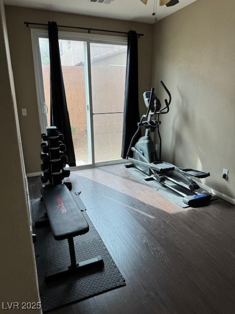 workout room featuring a healthy amount of sunlight, wood finished floors, and baseboards