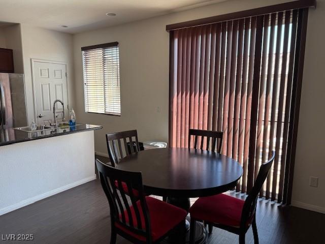 dining space with baseboards and dark wood-style floors