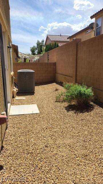 view of yard with central AC unit and a fenced backyard