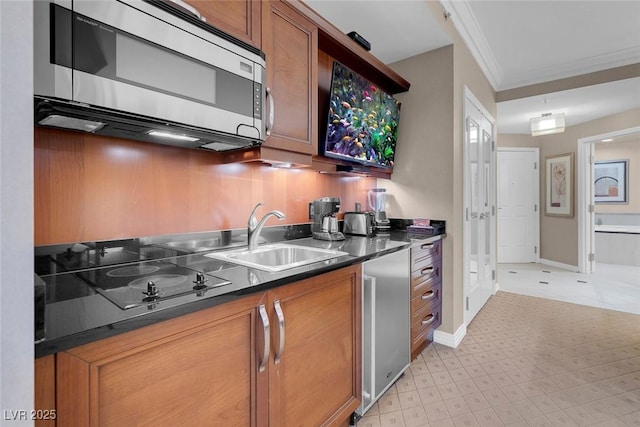 135 E Harmon Ave Unit 2515, Las Vegas, NV 89109 - kitchen with stainless steel microwave, dark countertops, a sink, brown cabinetry, and black electric stovetop