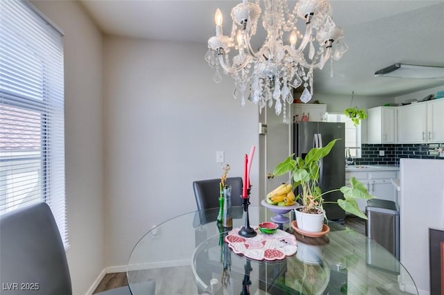 698 S Racetrack Rd Unit 1521, Henderson, NV 89015 - dining room with a chandelier, light wood-style floors, and baseboards