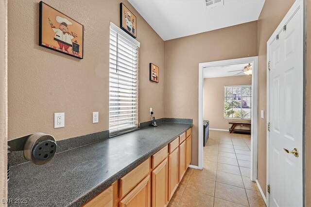 8828 Monte Oro Dr, Las Vegas, NV 89131 - kitchen featuring dark countertops, light tile patterned floors, and ceiling fan