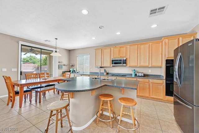 8828 Monte Oro Dr, Las Vegas, NV 89131 - kitchen with black appliances, light brown cabinetry, dark countertops, light tile patterned floors, and a breakfast bar