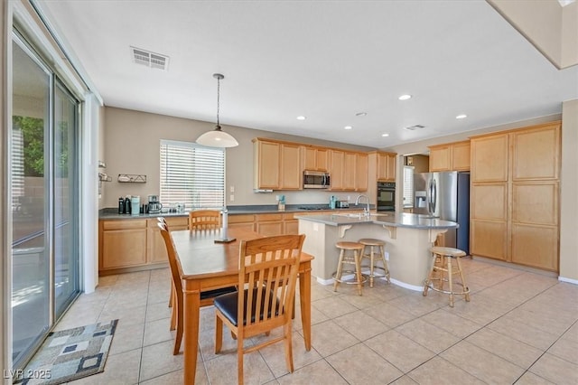 8828 Monte Oro Dr, Las Vegas, NV 89131 - kitchen with appliances with stainless steel finishes, light brown cabinetry, light tile patterned flooring, recessed lighting, and a center island with sink