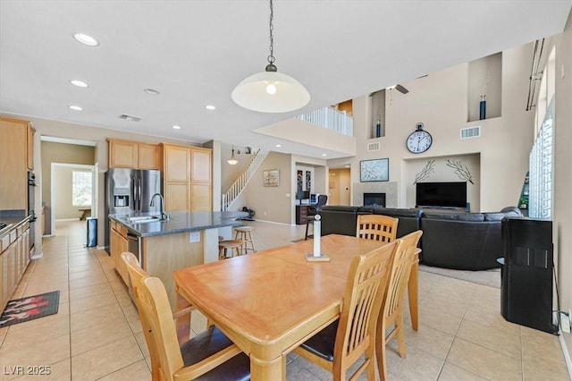 8828 Monte Oro Dr, Las Vegas, NV 89131 - dining room featuring a fireplace, light tile patterned flooring, stairway, and recessed lighting