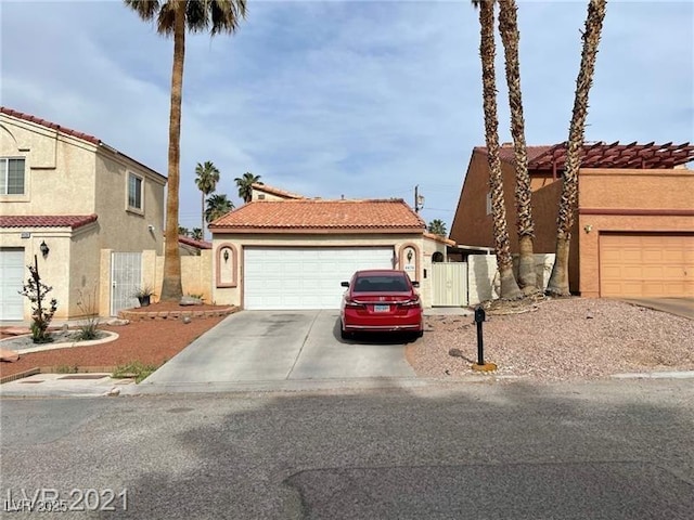4434 Los Reyes Ct, Las Vegas, NV 89121 - view of front of home with concrete driveway, stucco siding, a tiled roof, and a gate