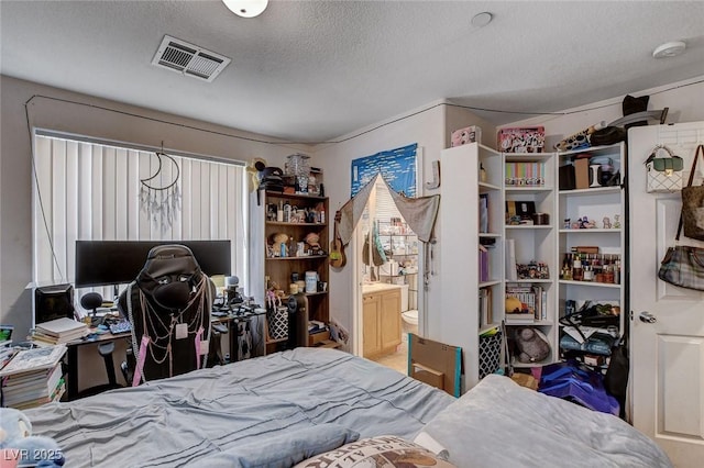4777 Mereworth Ct, Las Vegas, NV 89130 - bedroom with visible vents, ensuite bath, and a textured ceiling
