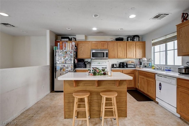 4777 Mereworth Ct, Las Vegas, NV 89130 - kitchen featuring stainless steel appliances, visible vents, a kitchen bar, and light countertops