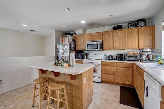 4777 Mereworth Ct, Las Vegas, NV 89130 - kitchen with visible vents, a kitchen island, light countertops, stainless steel appliances, and a breakfast bar area
