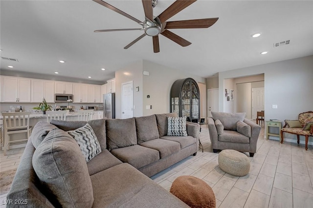 living room with a ceiling fan, visible vents, and recessed lighting
