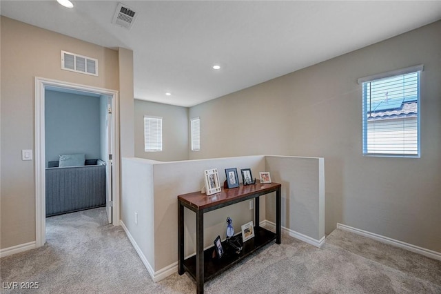 hallway with visible vents, carpet floors, and recessed lighting