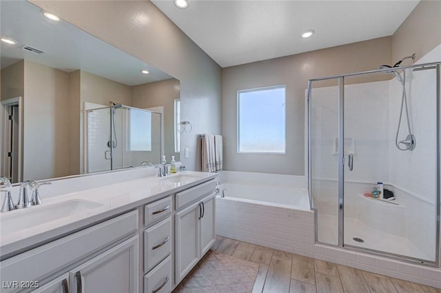 bathroom with a bath, visible vents, a stall shower, and a sink