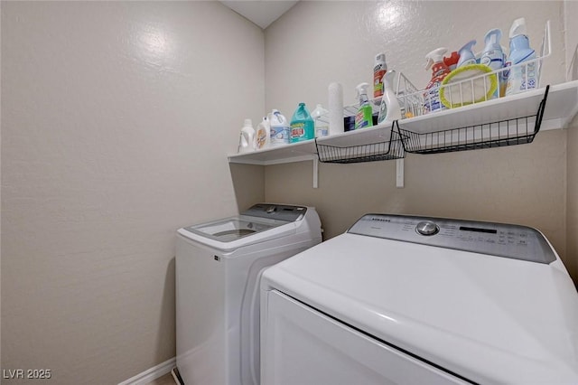 clothes washing area with washing machine and clothes dryer, baseboards, and laundry area