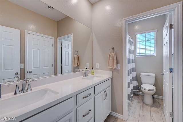 full bathroom with visible vents, a sink, double vanity, and toilet