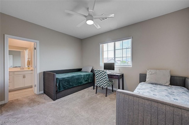 bedroom with a sink, ensuite bathroom, baseboards, visible vents, and light colored carpet