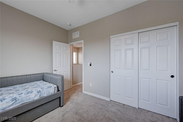 bedroom with baseboards, a closet, visible vents, and carpet